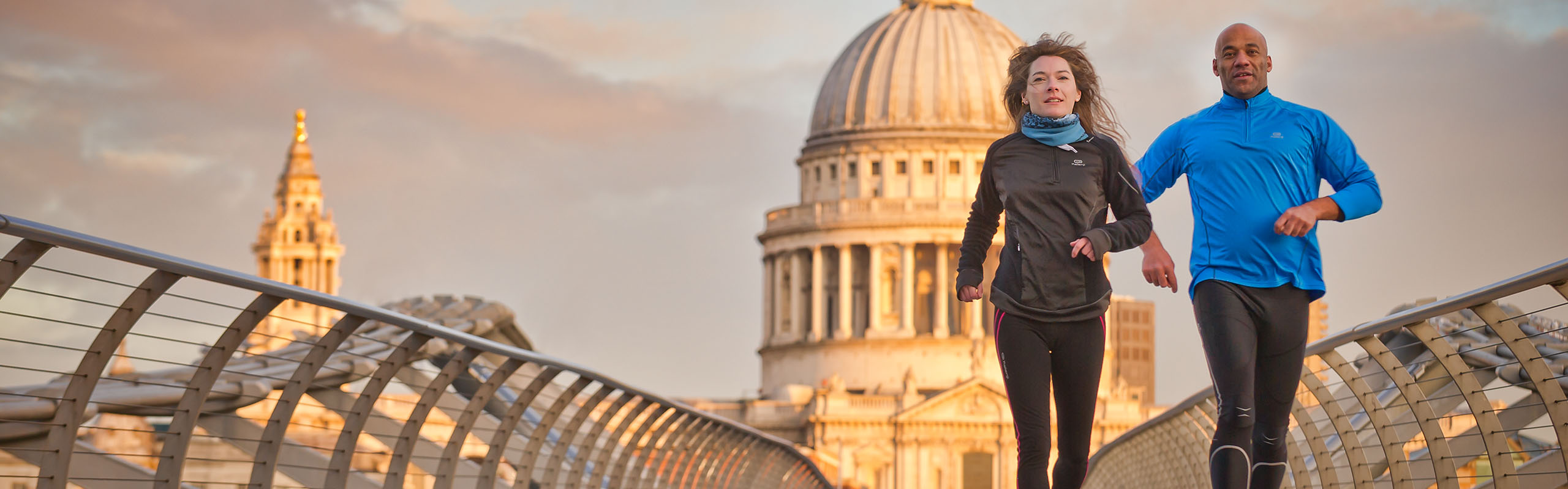 Two runners on London's Millennium bridge with St Paul's Cathedral in the background