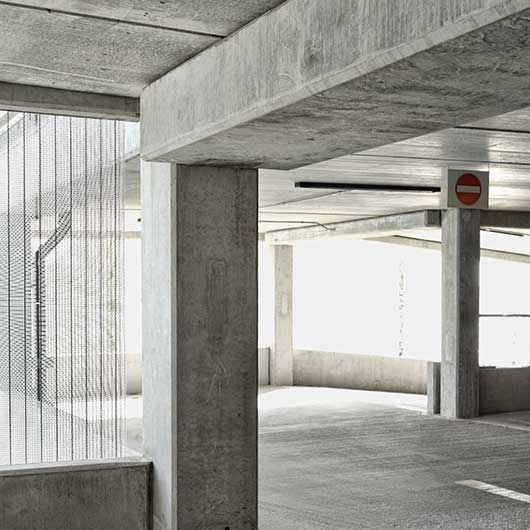 Detail of a part a car park showing a concrete pillar and stark surface