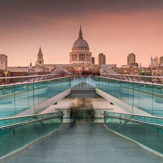 The Sir Christopher Wren designed St Paul's Cathedral and the Norman Foster designed Millennium Bridge photographed at sunset using a long exposure