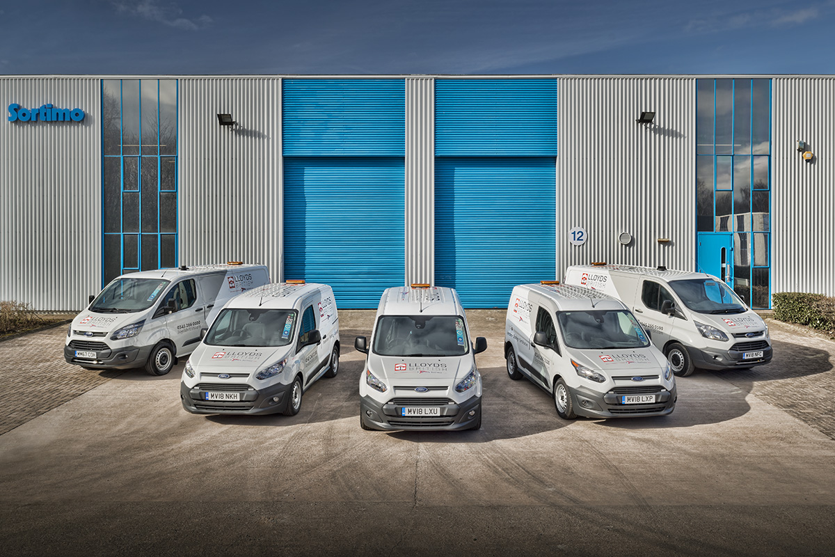 Set of vans arranged in front of a building.