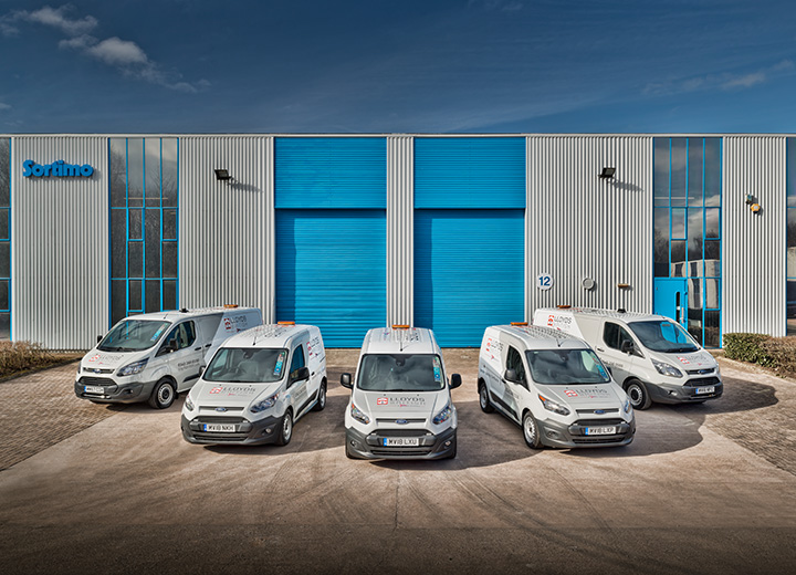 A group of small vans arranged outside a commercial building in Manchester