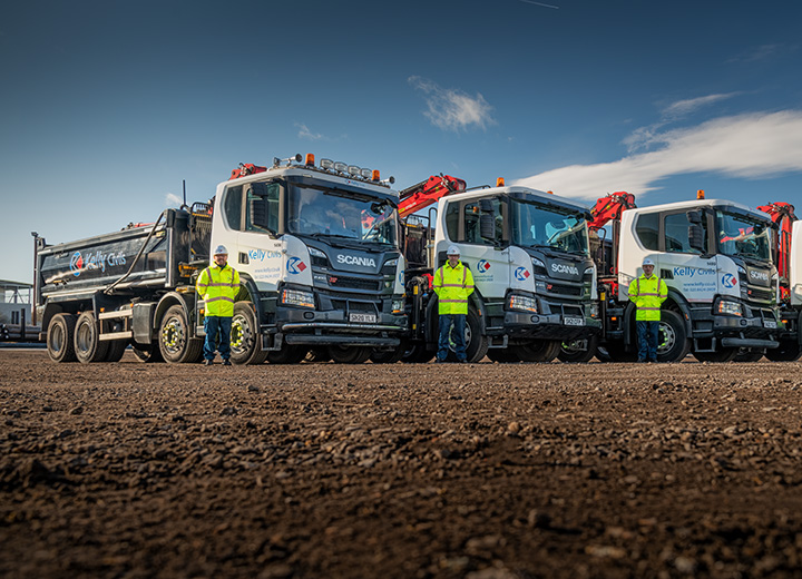 A group of drivers standing besides their lorries in a depot in Kent