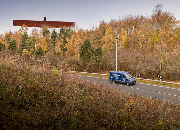 A delivery van driving past the Angel of the North, Gateshead.