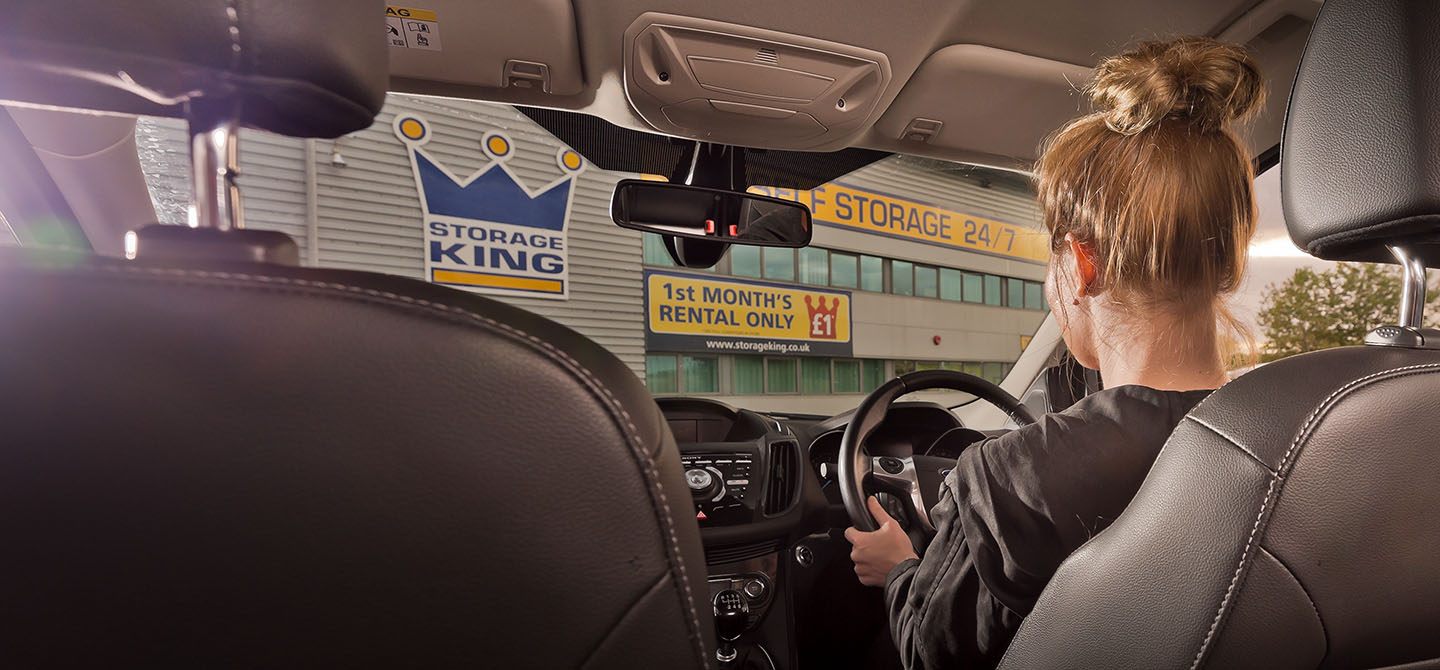 Young woman driving to a storage facility.