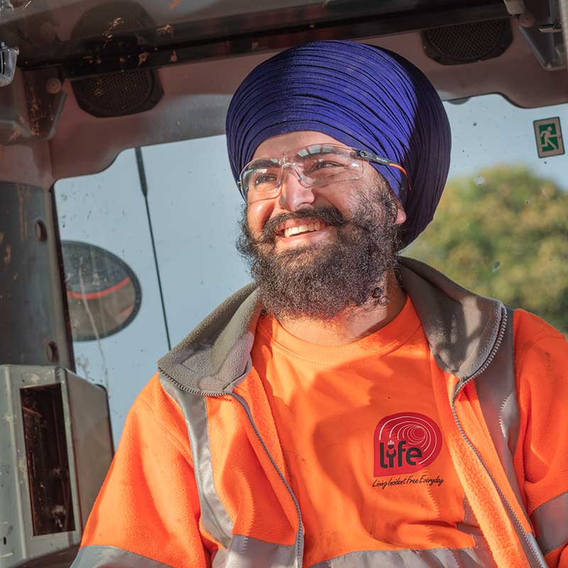 Photograph of a happy worker in orange Hi Viz