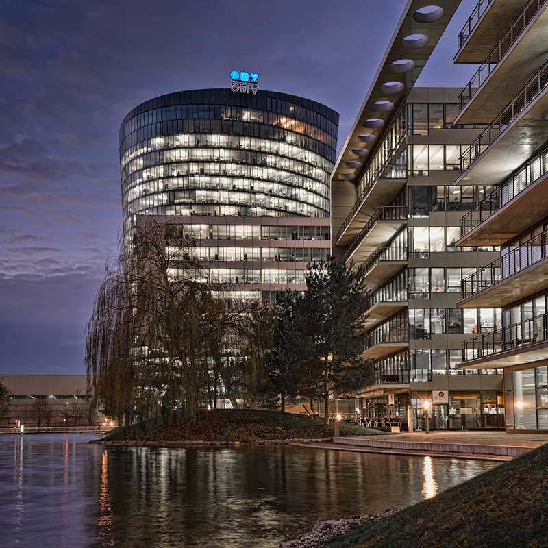 Head office building photographed in the eveningg with the lights reflecting in a lake