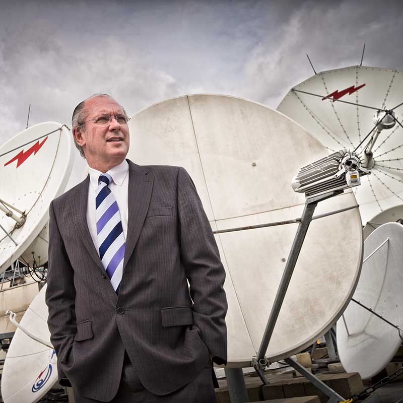 Senior executive photographed infront of some satalite dishes