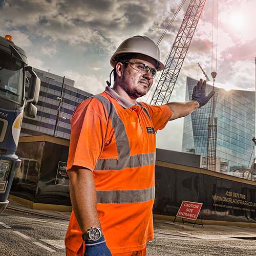 A Banksman directing traffic at a London construction site photographed for the Considerate Constructors Scheme.