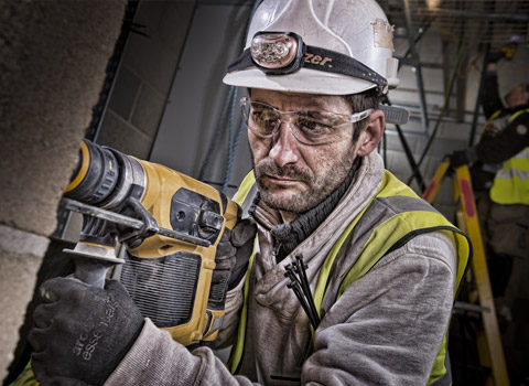 Worker using a deWalt drill on a site in East London