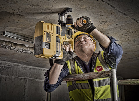 Construction site photography of worker using a deWalt power tool