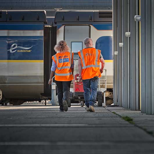 Two workers walking towards a train at the Eurostar Engineering Centre in Leyton.