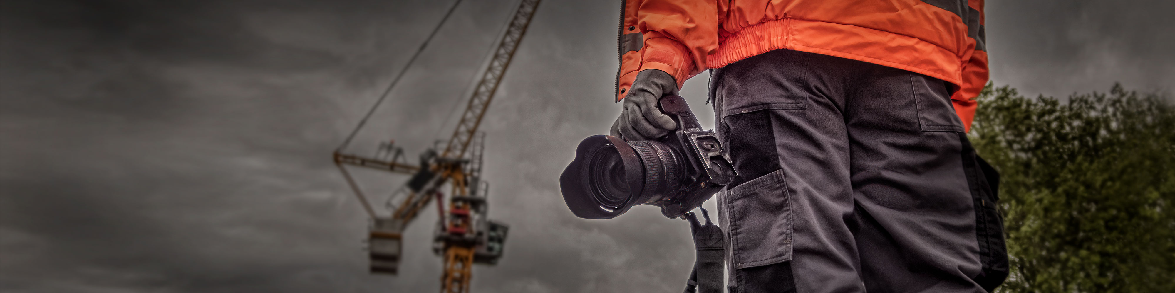 Commercial photographer holding a camera on a construction site