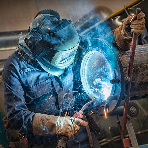 Photograph of a welder in an industrial site in London