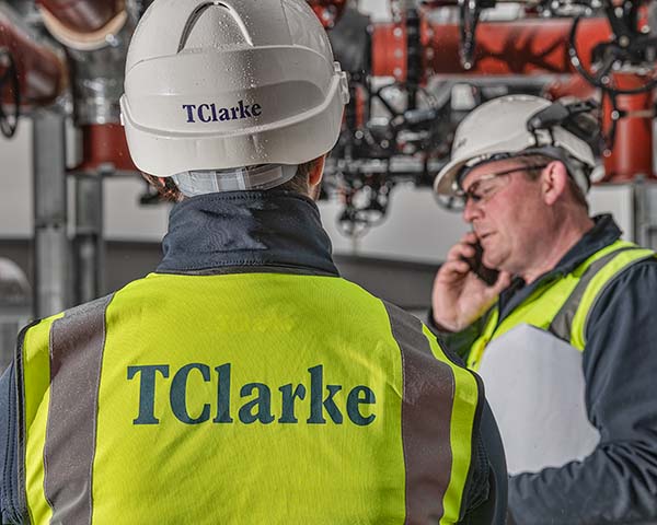 Construction worker on a phone, calling a photographer to book a shoot