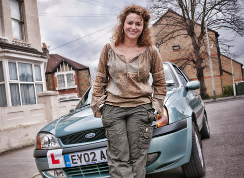 Woman standing by a car with an L plate