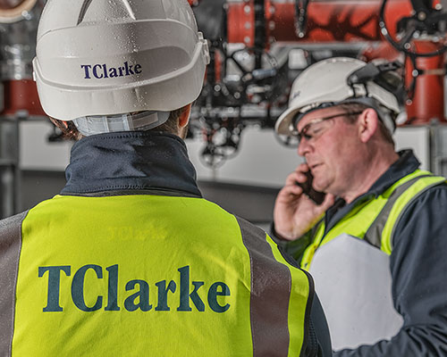 Construction worker on a phone, calling a photographer to book a shoot