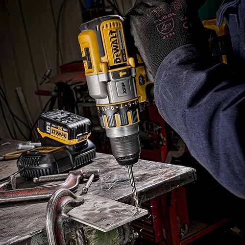 A deWalt drill photographed being used in a workshop.