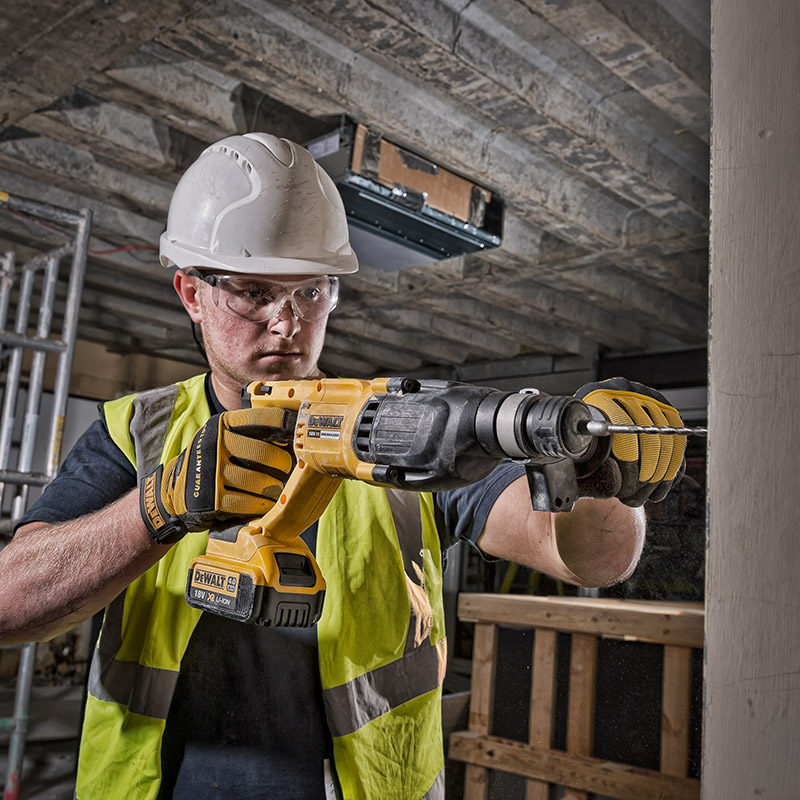 Advertising photography of a worker using a deWalt drill on a construction site