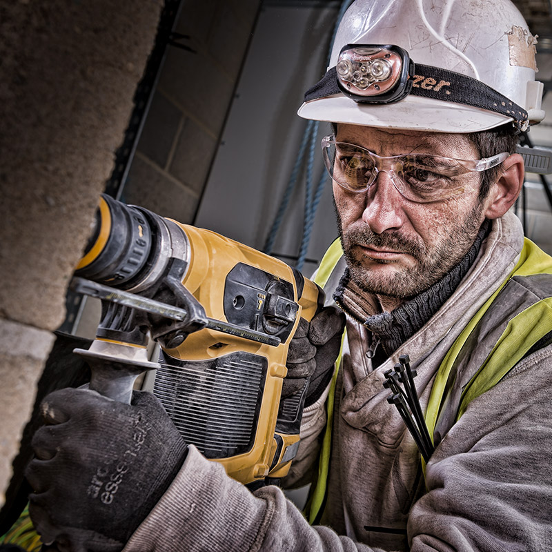 Worker using a deWalt drill on a construction site for a deWalt advertising campaign