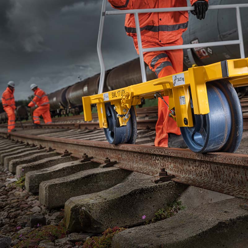Workers on a railway with a yellow trolley on the track