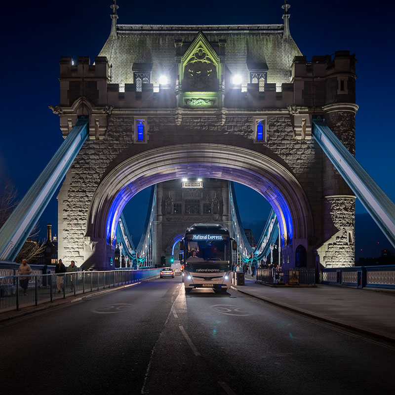 A National Express coach crossing Tower Bridge in London at night