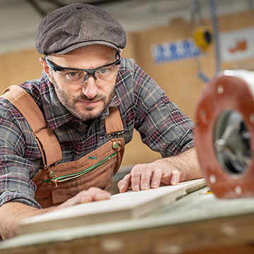 inspecting a piece of timber before cutting in a workshop