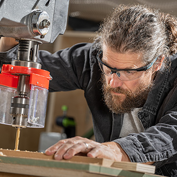 Worker concentrating while using a pillar drill